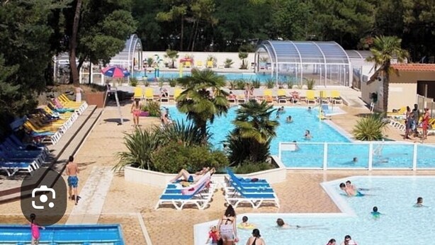 Ein Poolbereich mit mehreren Pools, Liegestühlen und Sonnenschirmen.