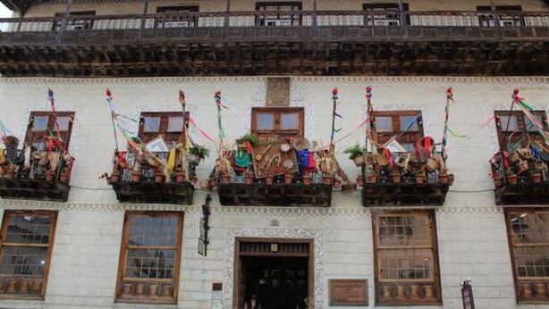 A building with multiple balconies adorned with traditional decorations and flags.