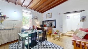 Una cocina acogedora con comedor, sofá y televisor.
