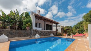 A swimming pool with "FINCA PARIS" written on the tiles, surrounded by a stone wall and a house with a tiled roof. - Remarkable 4-bed Villa (San Cristóbal de La Laguna)