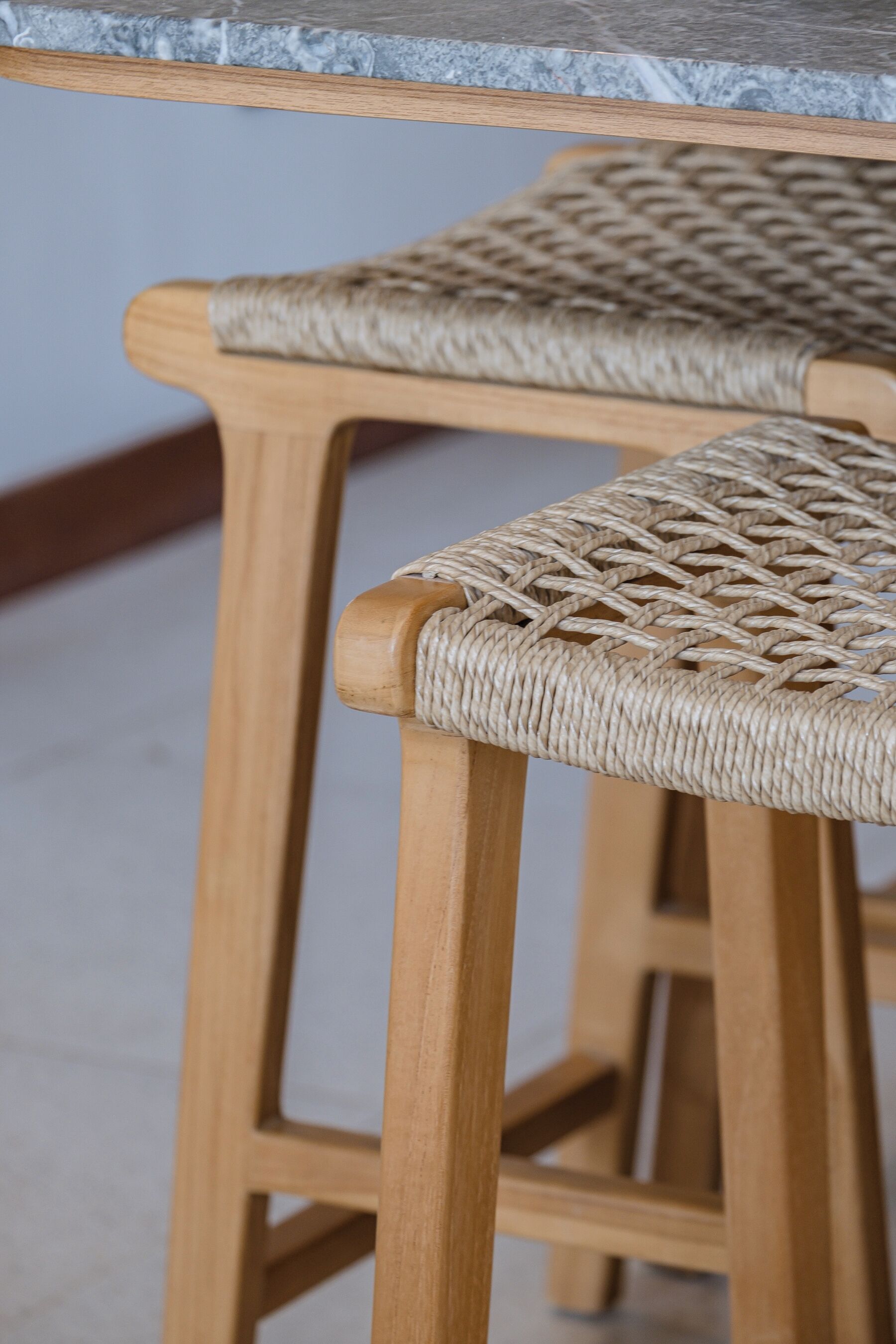 A close-up of a wooden chair with a woven seat and backrest.