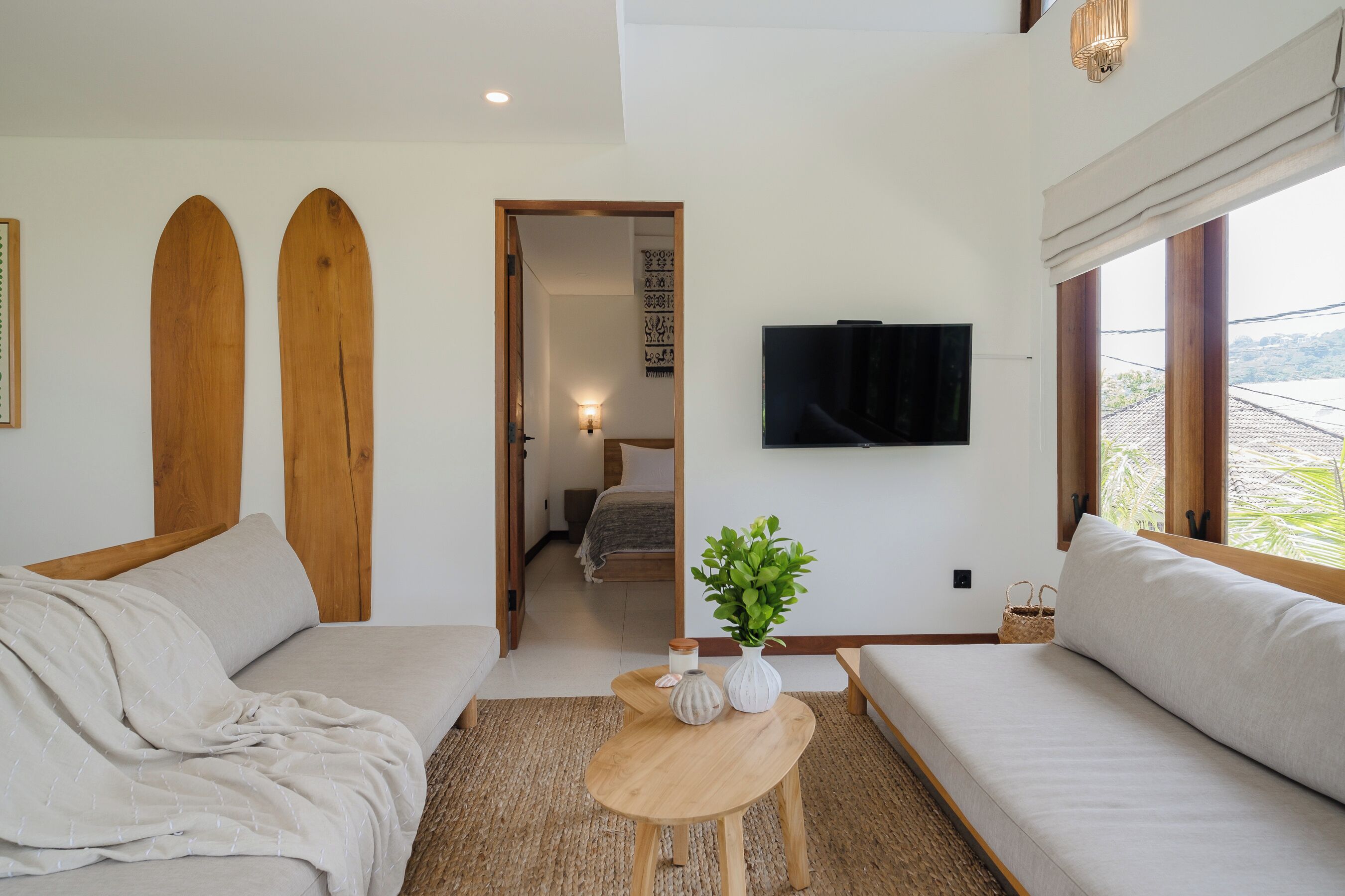 Ein modernes Wohnzimmer mit einer Couch, einem Couchtisch und einem an der Wand montierten Fernseher.