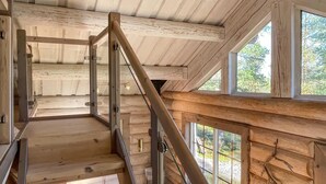Eine Holztreppe mit Metallgeländern, die zu einer oberen Etage führt.