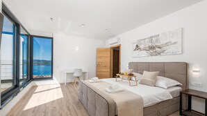 Une chambre moderne avec un grand lit, un bureau et une vue sur la mer.