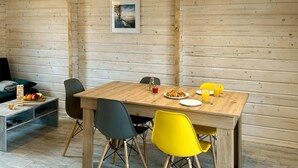 A wooden dining table with chairs, a framed picture on the wall, and a fruit basket on the side table. - Gorgeous home in Sarbinowo with WiFi (Sarbinowo)