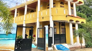 A two-story building with a yellow facade, multiple balconies, and a covered entrance. - Bungalows Isla bonita (Rincón de Guayabitos)