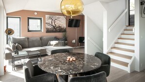 A modern living room with a round marble table, grey sofa, and a staircase. - 4 bedroom nice home in Sætre (Sætre)