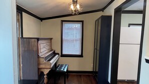 A hallway with a piano, a bench, and a window with blinds. - Charming 2-bedroom cottage in wonderful Newburg with WiFi, AC (Newburg)