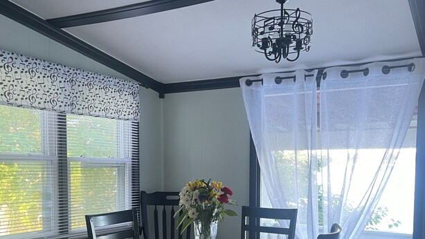 A dining area with a round wooden table, six chairs, a vase with flowers, and a ceiling fan. - Charming 2-bedroom cottage in wonderful Newburg with WiFi, AC (Newburg)
