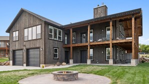 A two-story wooden house with a fire pit in the front yard. - Modern Lakehouse l Slps 34 l Courts + Chefs Kitchen l Bear Lake Haven (Saint Charles)