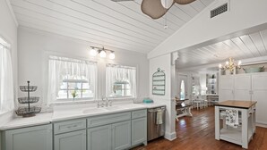A spacious kitchen with light blue cabinets, a wooden countertop, and a central island. - New List - Heated Pool Golf Cart Bikes Sleeps 12 (Santa Rosa Beach)
