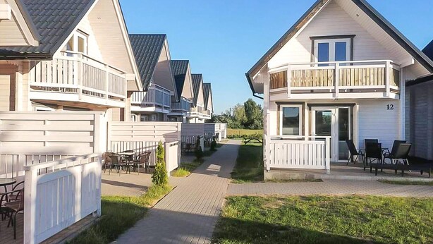 A row of modern, two-story houses with balconies, a paved walkway, and outdoor furniture. - 2 bedroom stunning home in Sarbinowo (Sarbinowo)