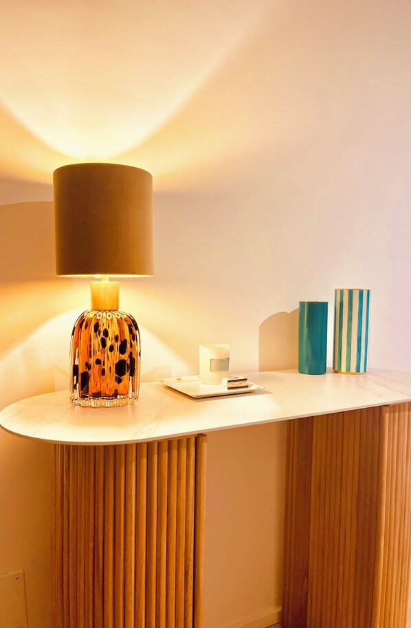 A table with a lamp, a candle, and decorative vases. - Pasubio Luxury Boutique apartment (Roma)
