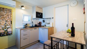 A compact kitchen with a microwave, stove, and sink. There's a small window and a clock on the wall. - 1 bedroom gorgeous apartment in Necujam (Necujam)