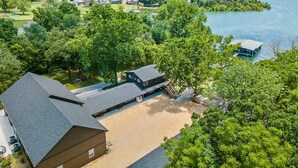 A lakeside property with a large building, a dock, and a boat.