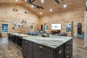 Une cuisine spacieuse dotée d’un plan de travail en marbre, de meubles en bois et d’un coin repas avec des chaises.
