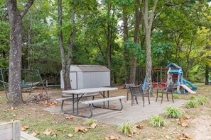 A picnic area with a table and benches, surrounded by trees.