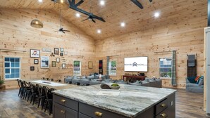 A spacious wooden interior with a central island, dining area, and seating.