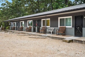Fileira de cabanas com área externa para sentar, hidrante e calçada de cascalho.