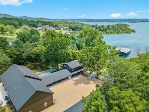 A lakeside property with a large building, a dock, and a boat.