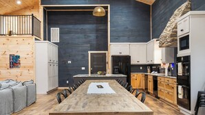 A modern kitchen with a central island, wooden cabinets, and a stone accent wall.