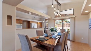 A modern dining area with a wooden table set for four, surrounded by chairs. - Sedona Among the Rocks: Luxurious 3BR home with stunning Red Rock views in the Chapel Area. (Sedona)