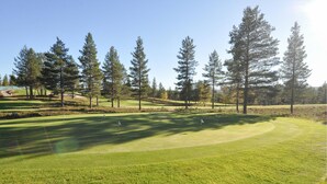 A golf course with a well-maintained fairway, sand bunkers, and a variety of trees. - Gorgeous home in Idre with sauna (Idre)