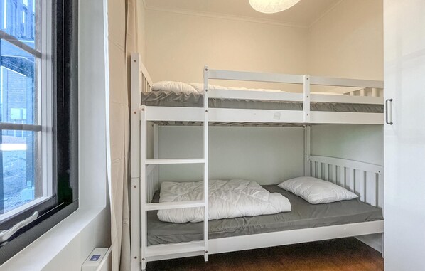 A bunk bed room with a window, a door, and a light fixture. - Gorgeous home in Idre with sauna (Idre)