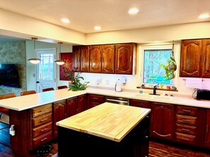 Una cocina moderna con armarios de madera, una isla central y un comedor.