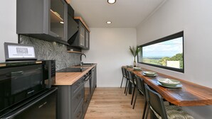 A modern kitchen with a wooden countertop, a built-in oven, and a view of the outdoors through a large window. - Luxurious home in Banfi with sauna (Banfi)