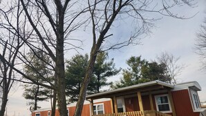 A mobile home with a wooden deck and a small porch.