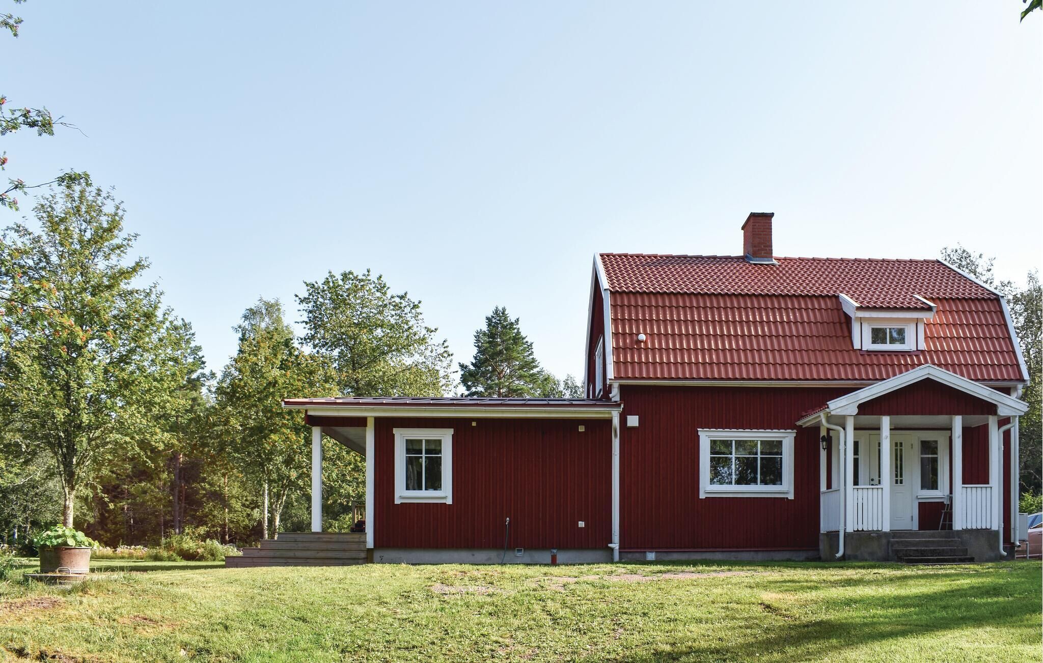 A red two-story house with a covered porch and a small attached garage.