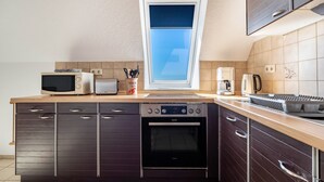 Una cucina compatta con forno, microonde e tostapane integrati.