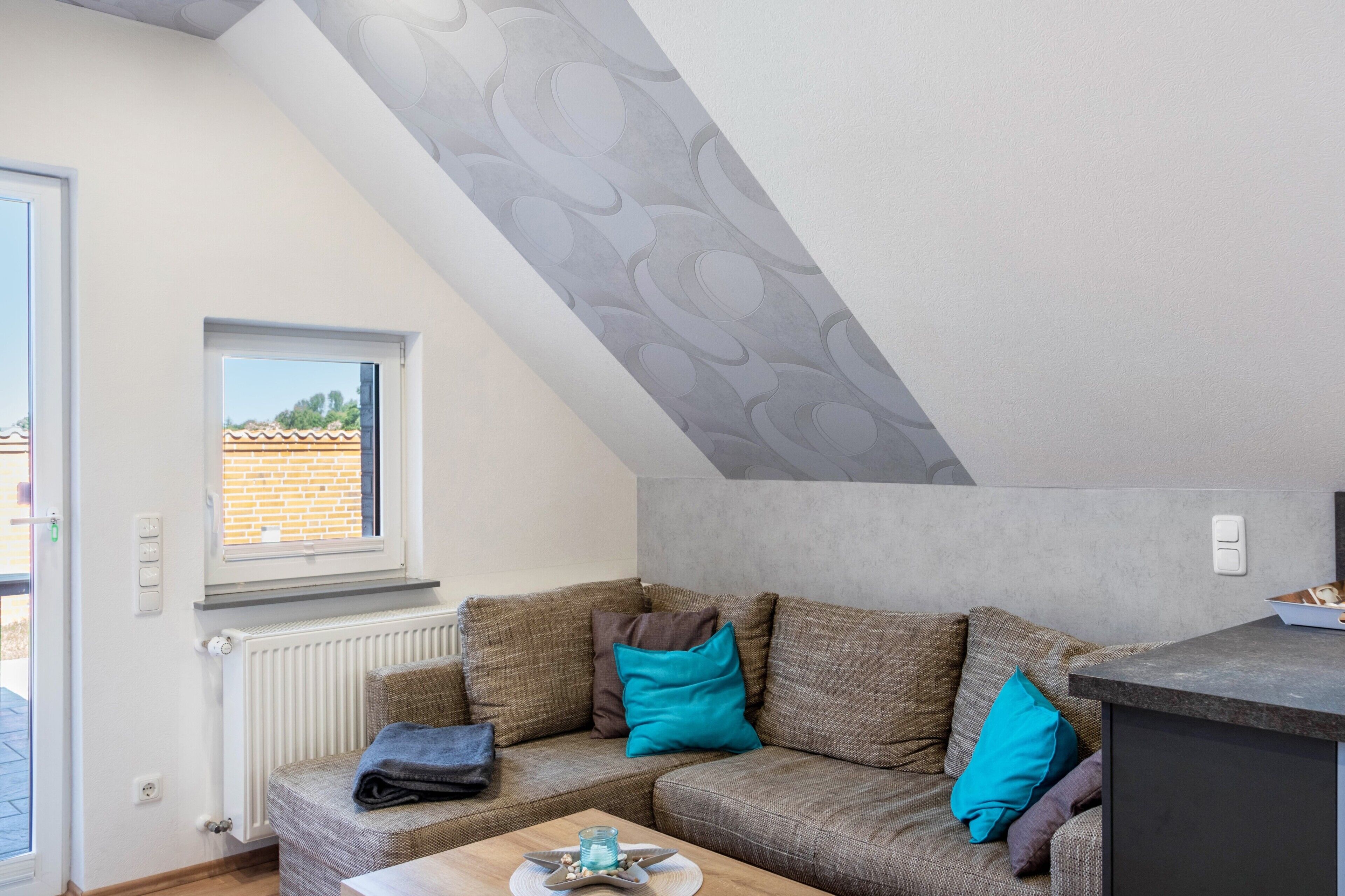 Una sala acogedora con sofá, una mesita, una ventana y un radiador.