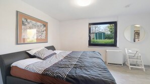 A bedroom with a bed, a radiator, a window, and a ladder. - New Central Apartment with Wi-Fi in Stuttgart (Stuttgart)