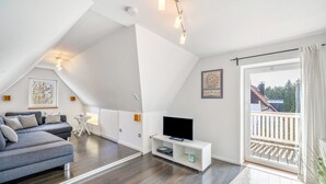 A modern living room with a sofa, TV, and a balcony. - Apartment "Bayerl" with Mountain View, Balcony and Wi-Fi (Kirchseeon)