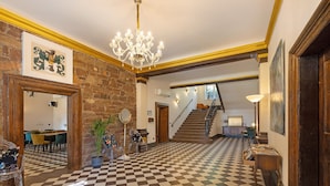 A checkered floor, a chandelier, a staircase, and a dining area with chairs and a table. - Apartment 'Suite' with Shared Pool, Shared Terrace and Wi-Fi (Vitzenburg)