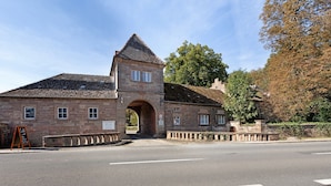 A stone building with a central archway, a clock tower, and a signboard. - Apartment 'Eremitage' with Shared Pool, Shared Terrace and Wi-Fi (Vitzenburg)