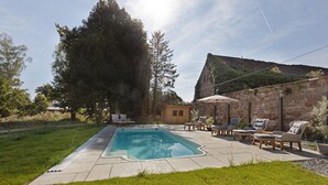 A swimming pool with lounge chairs and a stone wall. - Apartment 'Pauline' with Shared Pool, Shared Terrace and Wi-Fi (Vitzenburg)