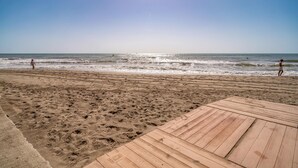 Une plage avec une promenade en bois qui mène à l’eau.