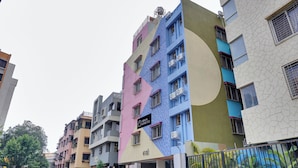 Un edificio residencial de varios pisos con balcones y unidades de aire acondicionado.
