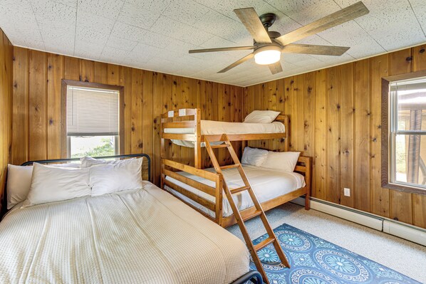 A room with wooden walls, a bunk bed, a ceiling fan, and a window with blinds. - Waterfront Cottage w/ Dock & Views in Six Lakes! (Six Lakes)