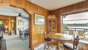 A wooden interior with a dining area, a view of the lake, and a 'Welcome' sign. - Waterfront Cottage w/ Dock & Views in Six Lakes! (Six Lakes)