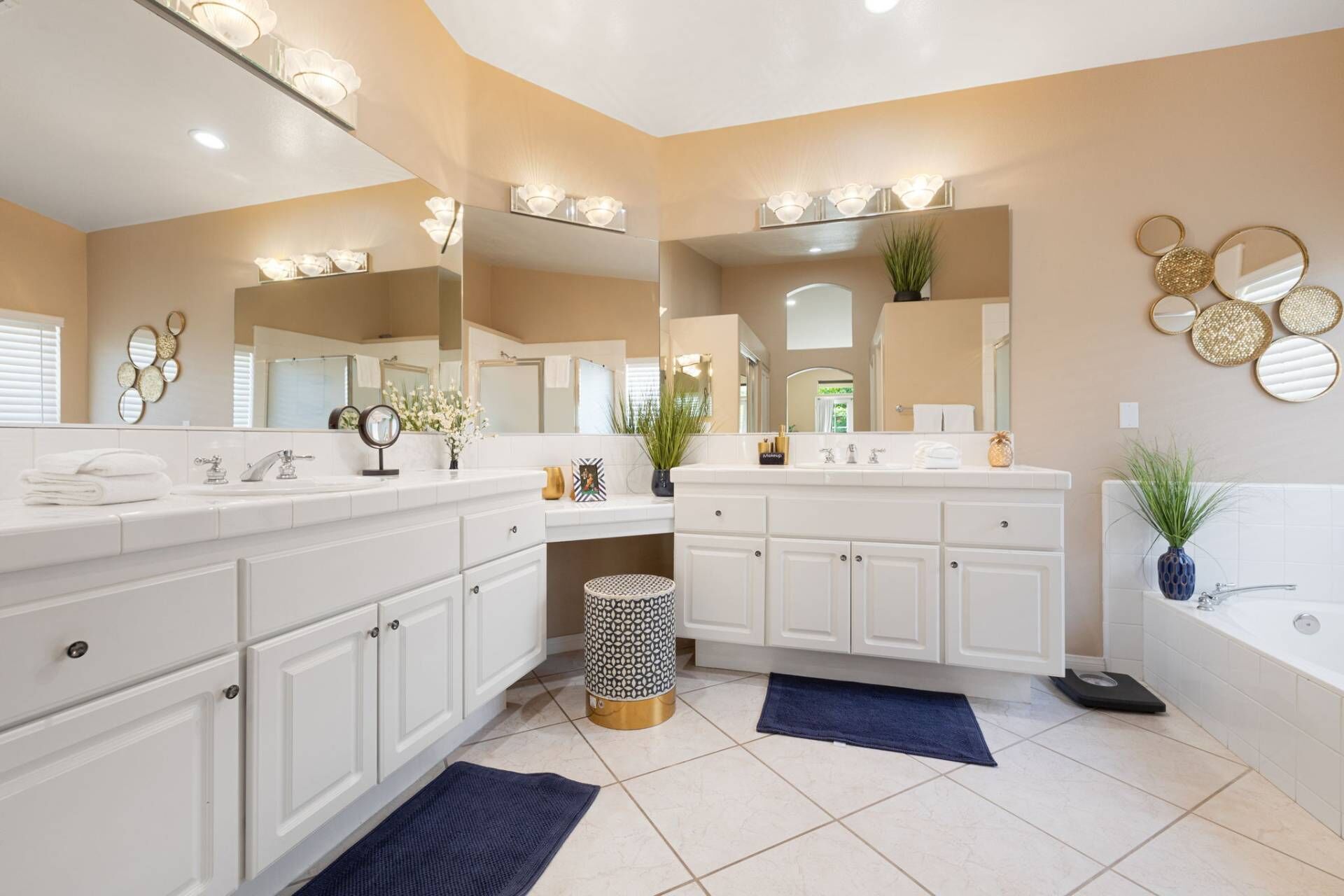 Une salle de bain moderne avec deux lavabos, un grand miroir et une baignoire.