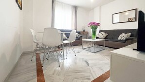 Un salon moderne comprenant un canapé, une table basse et un coin repas avec des chaises et une table.