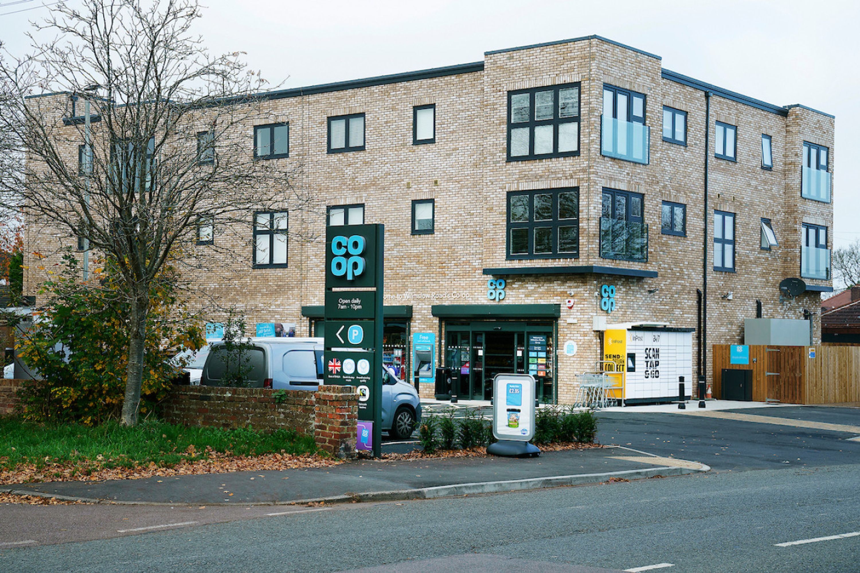 A multi-story building with a brick facade, a parking sign, and a storefront with a green awning.