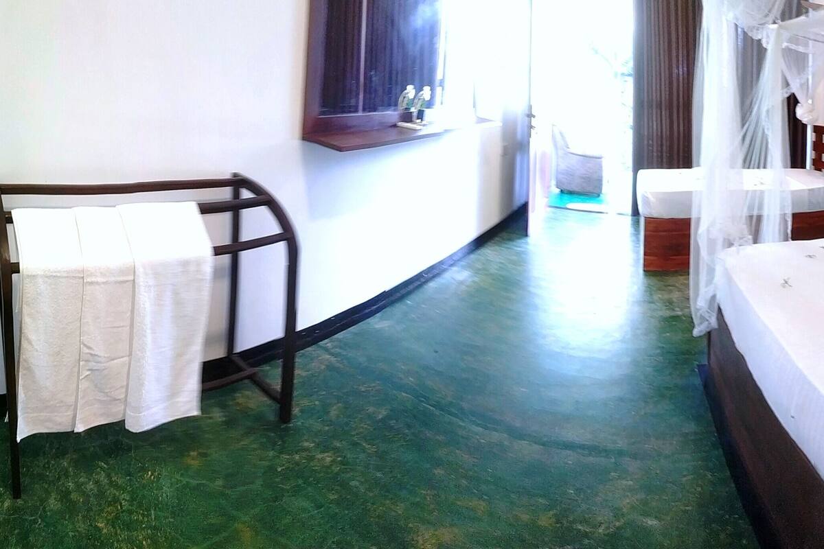 Una habitación con una cama, una mesita y una silla.