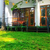 Una casa con porche, escaleras y un ventanal grande.