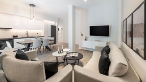 A modern living room with a sofa, coffee table, and a flat-screen TV mounted on the wall. - Lovely 3BR Apartment in Pangrati (Kesariani)