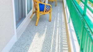 A balcony with a table and chairs, air conditioning units, and a green railing. - Sunny Dream House (Agios Ioannis Rentis)